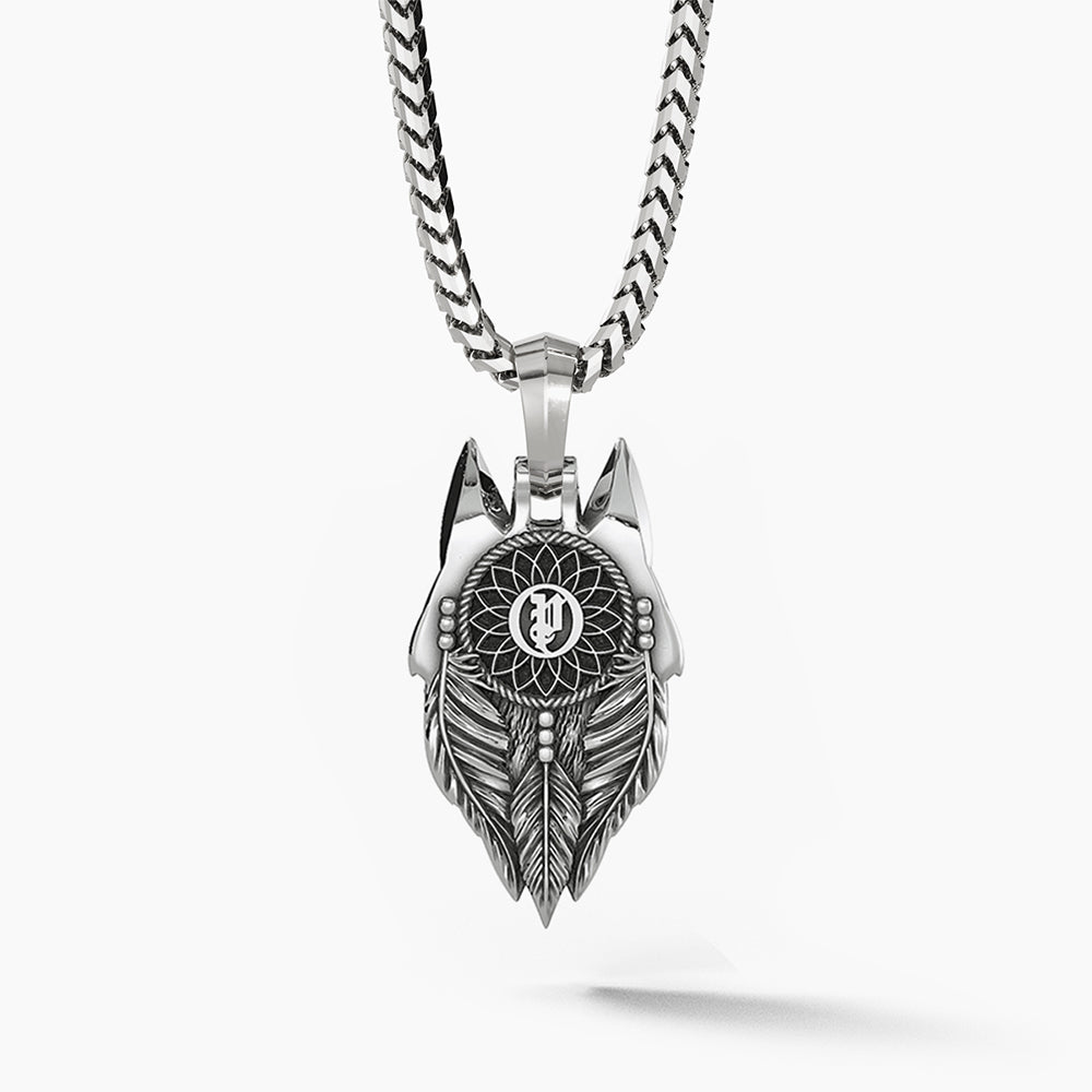 The back of a silver wolf pendant features a dreamcatcher