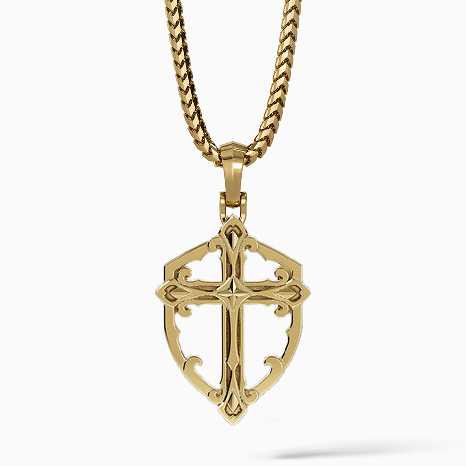 a shield-shaped mens gold cross necklace hangs from a chain