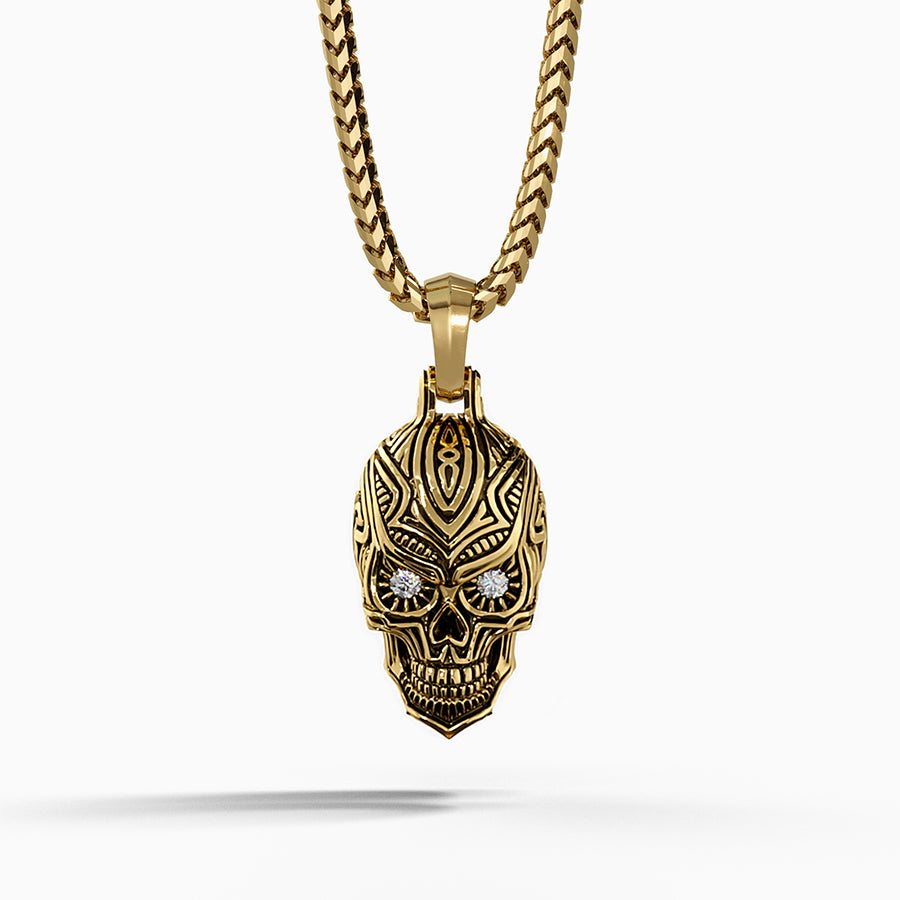 a gold sugar skull pendant hanging on a franco chain