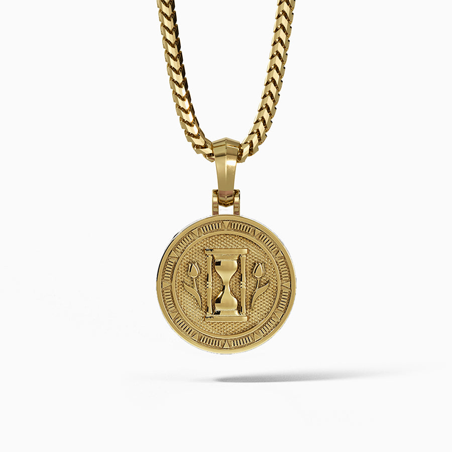 the back of a polished gold medallion for men with the hourglass and two sculpted tulips