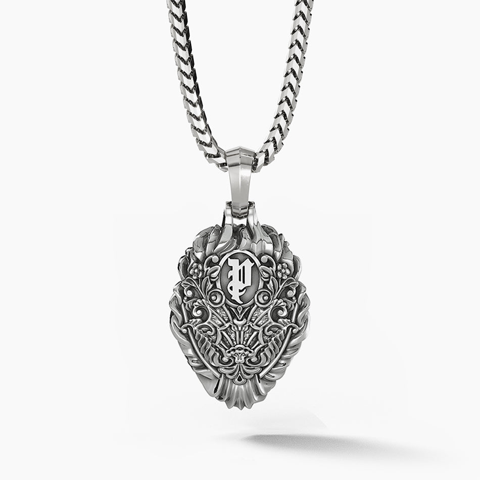 The back of a silver lion pendant features a royal pattern and the Proclamation Jewelry logo