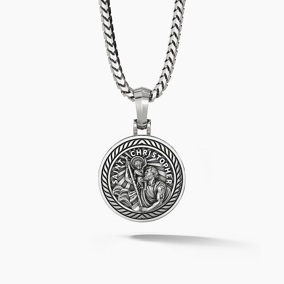 a round and polished silver Saint Christopher pendant with the sculpted saint carrying baby Jesus