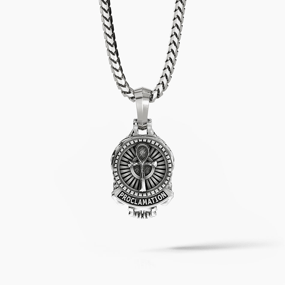 the back of a mens silver pendant features an ankh and detailed designs