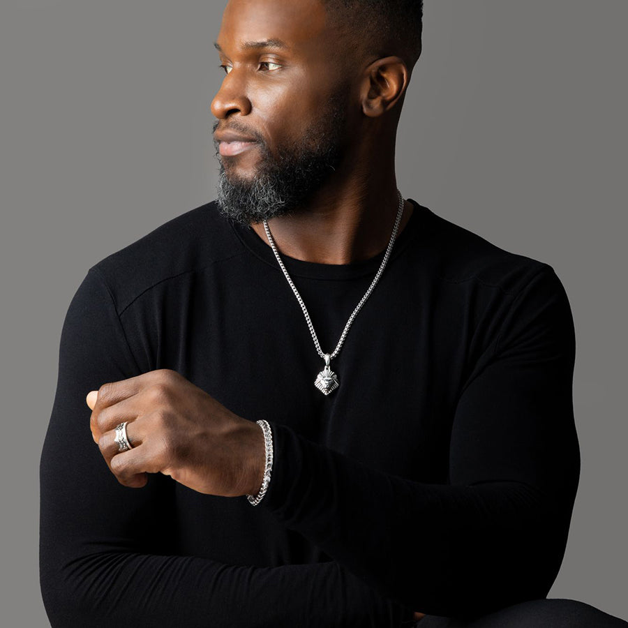 a man wears a shining silver lion pendant and matching silver bracelet